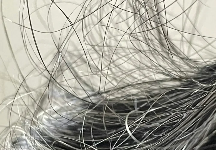 Close-up of thinning hair with loose and fine strands visible across the scalp