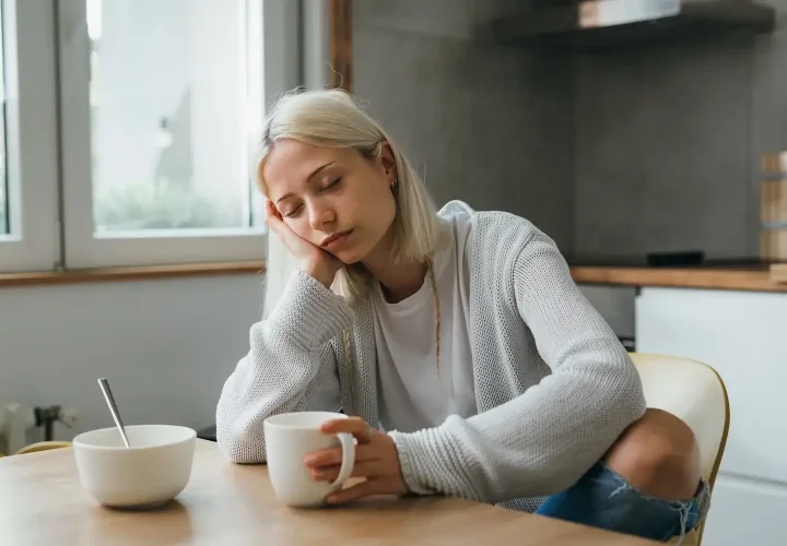 Woman asleep at the table representing healthy sleep and the connection between sleep apnea and mental health.